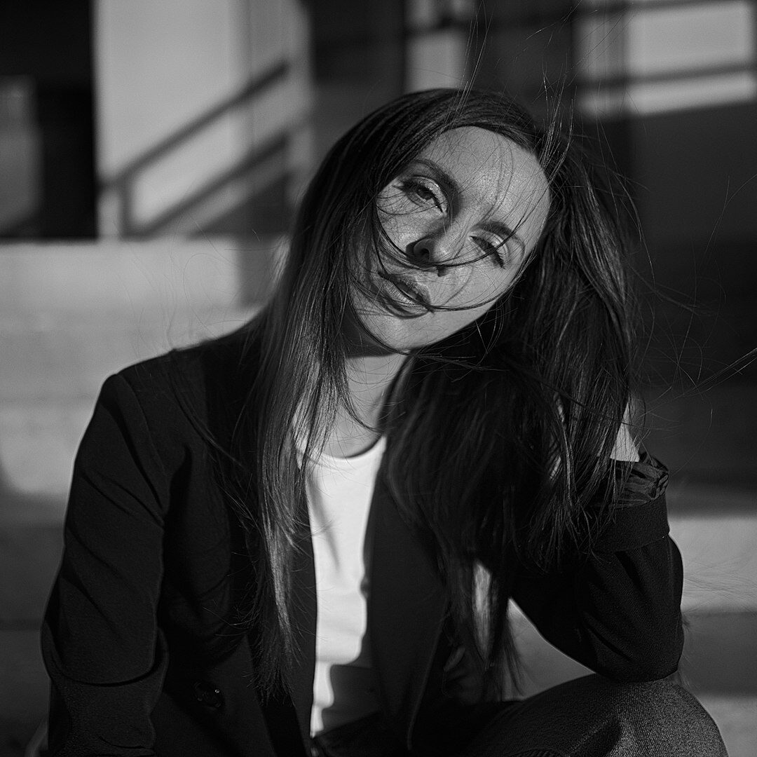 Woman in a black blazer smiling for a portrait