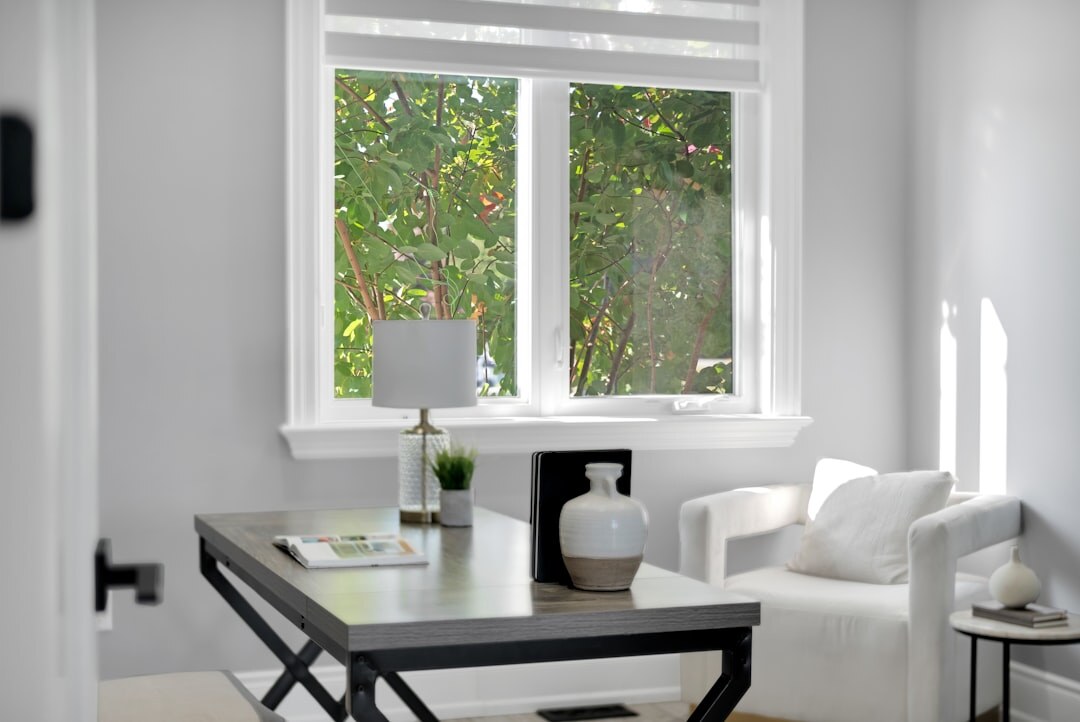 Editorial desk with an open laptop beside a window