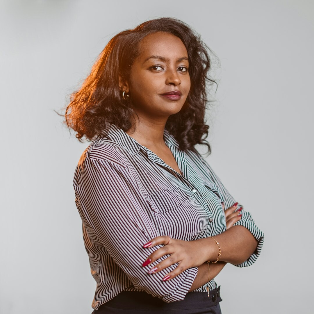 Woman in a striped dress and cardigan posing for a portrait